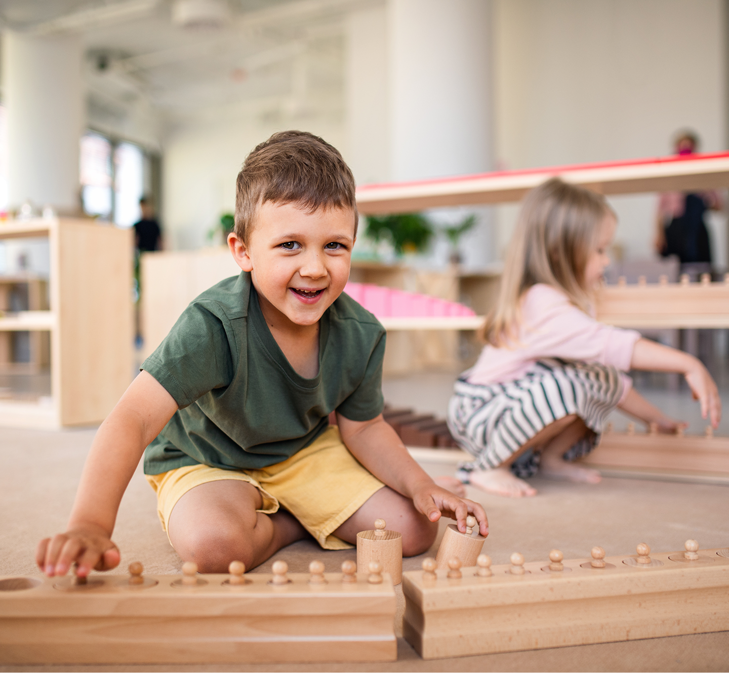 Children playing with wooden toys indoors.