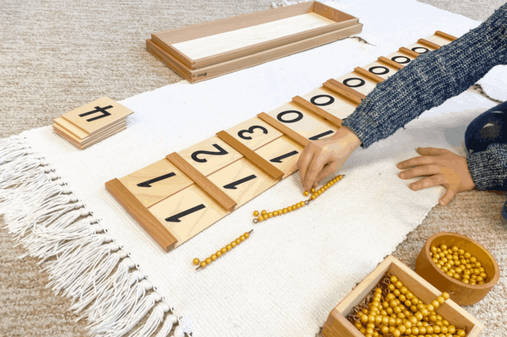 Montessori math activity with number cards and beads.