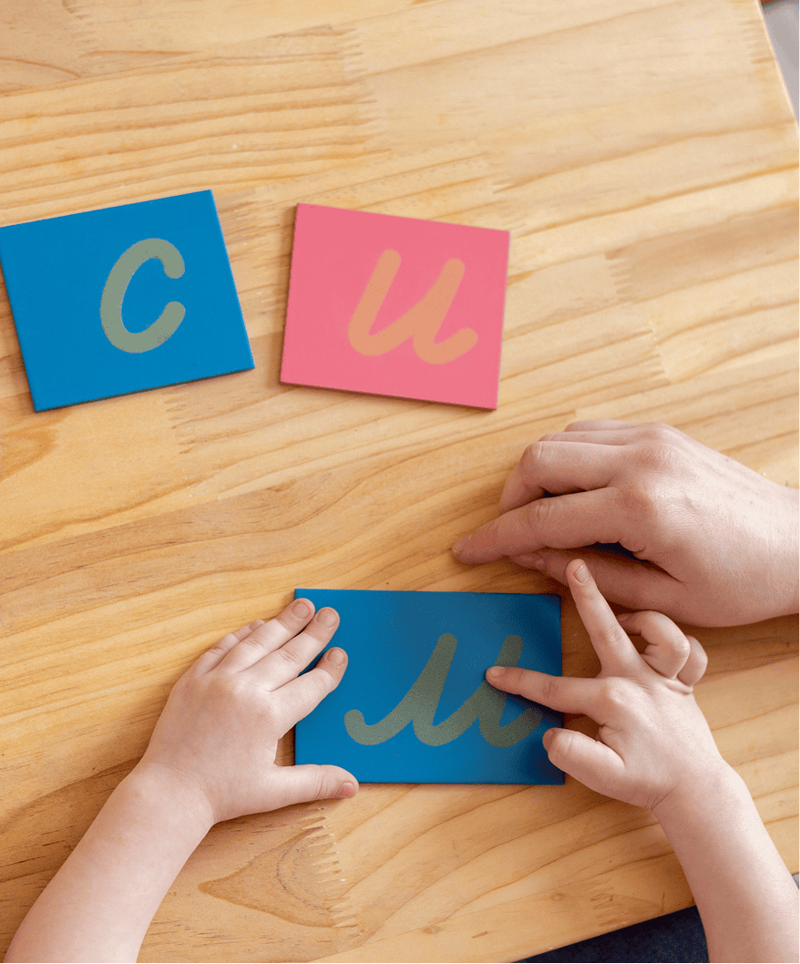 Child learning letters with adult guidance.