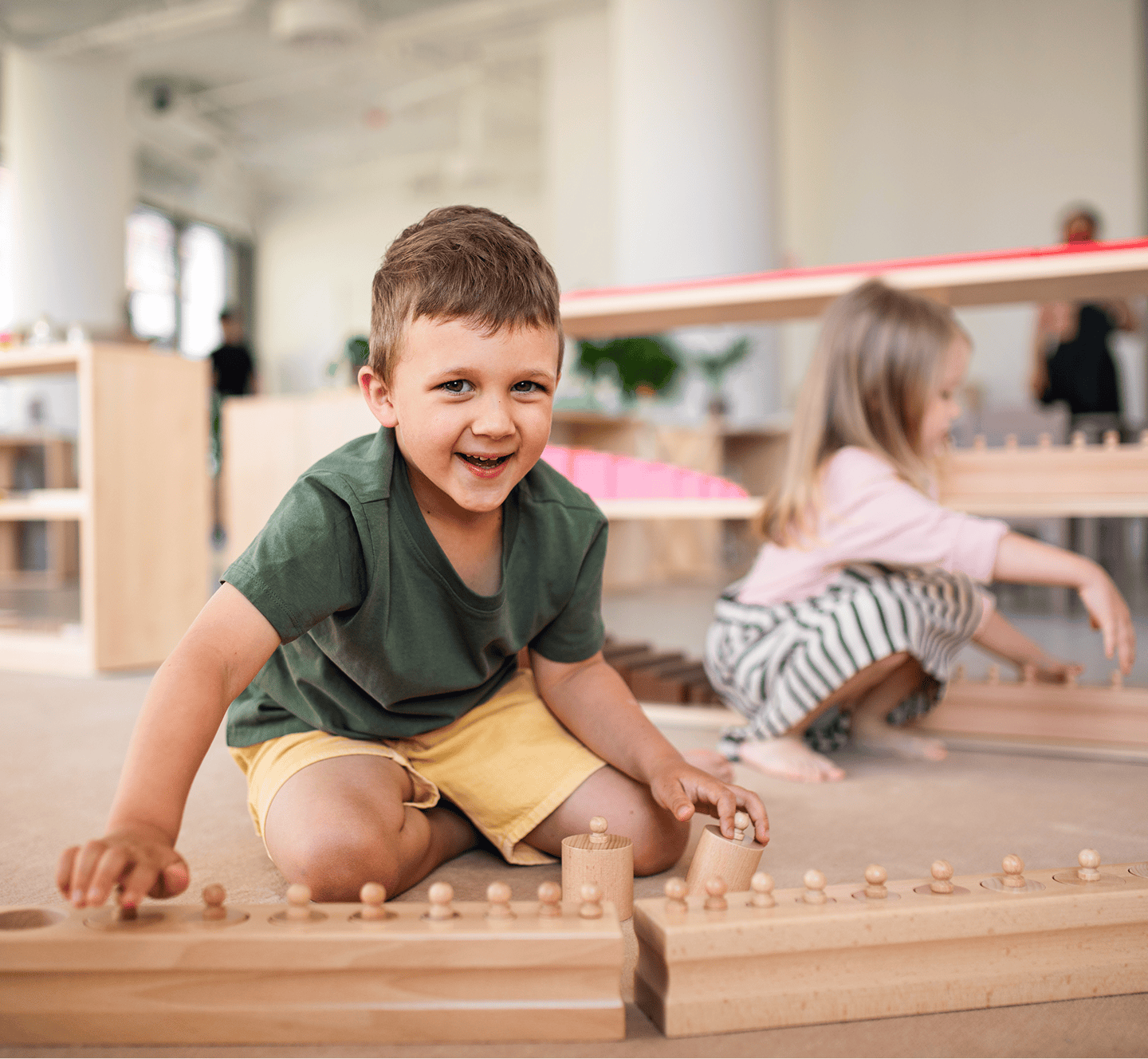Children playing with wooden toys indoors.